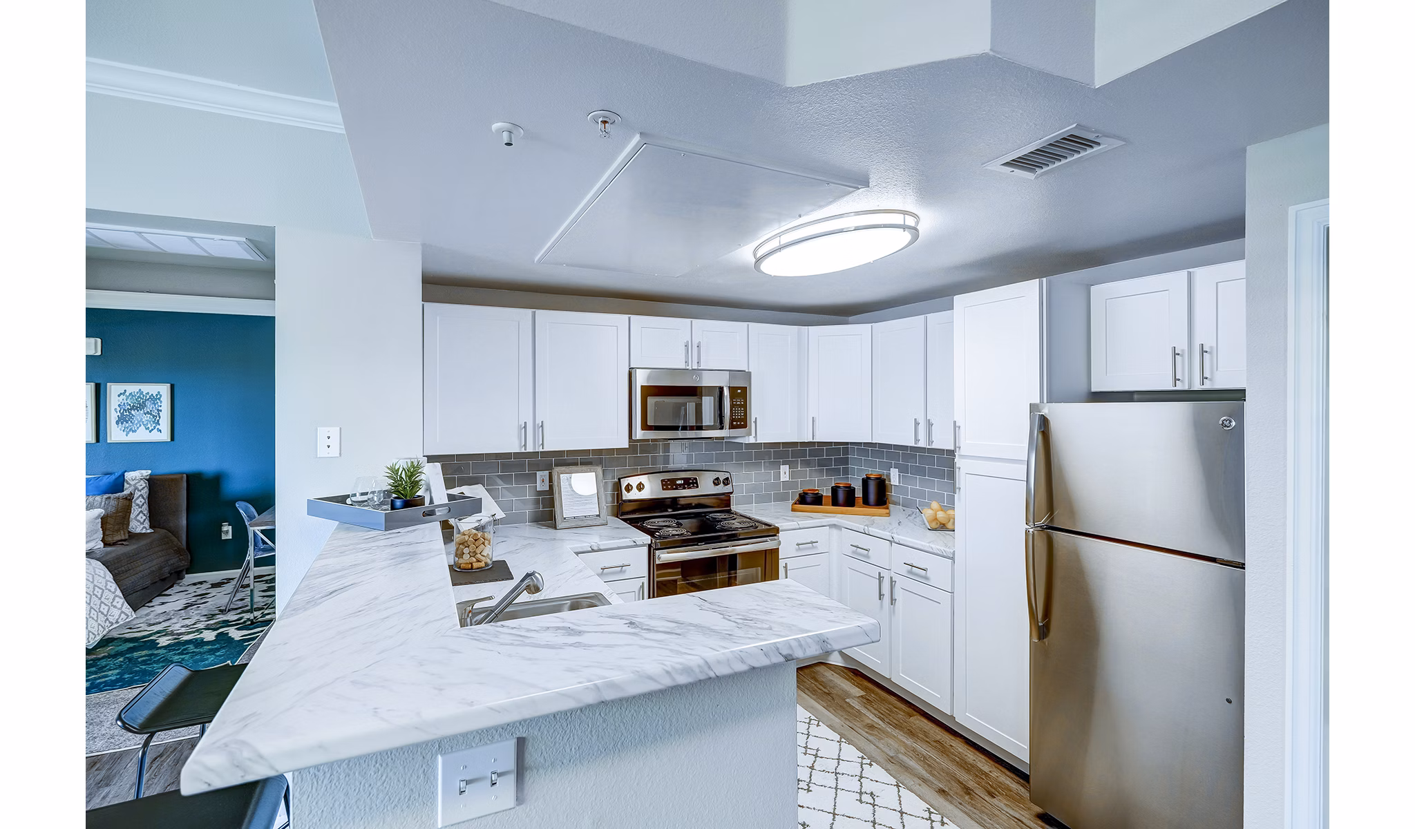 Modern kitchen with stainless steel appliances and granite countertops at The Fletcher Southlands Apartments, luxury living in Denver
