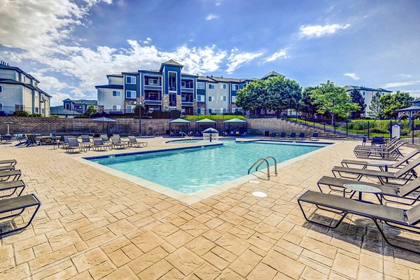 Pool with comfortable seating at The Fletcher Southlands Apartments, offering luxurious relaxation and leisure in a stunning outdoor setting