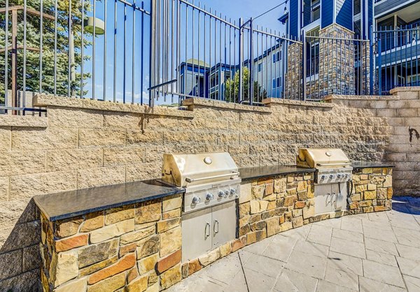 Grill area with outdoor seating at The Fletcher Southlands Apartments, offering luxury amenities in a vibrant community setting