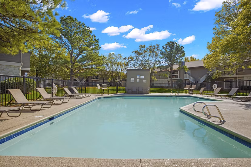 Eagle Point Apartments: Outdoor pool with sun loungers and shaded seating areas in Greystar luxury community