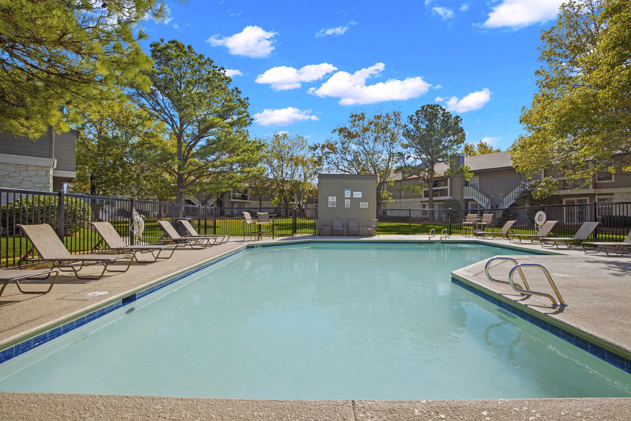 Eagle Point Apartments: Outdoor pool with sun loungers and shaded seating areas in Greystar luxury community