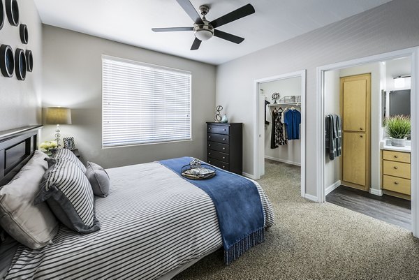 Bedroom with elegant decor and ample natural light at Laguna at Arrowhead Ranch Apartments