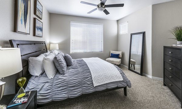 Cozy bedroom with modern decor at Laguna at Arrowhead Ranch Apartments, showcasing luxury living spaces in a serene setting