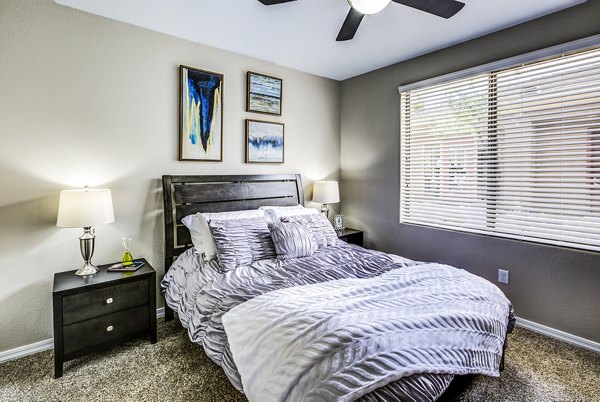 Bedroom featuring modern design and cozy ambiance at Laguna at Arrowhead Ranch Apartments
