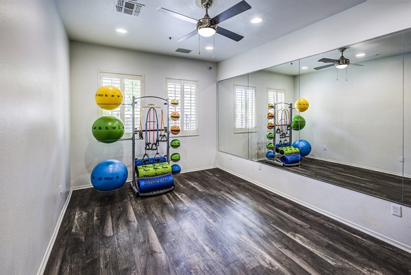 Yoga studio equipped with mirrored walls and wood flooring at Laguna at Arrowhead Ranch Apartments