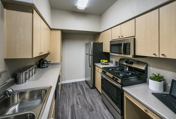 Modern kitchen with stainless steel appliances at Laguna at Arrowhead Ranch Apartments