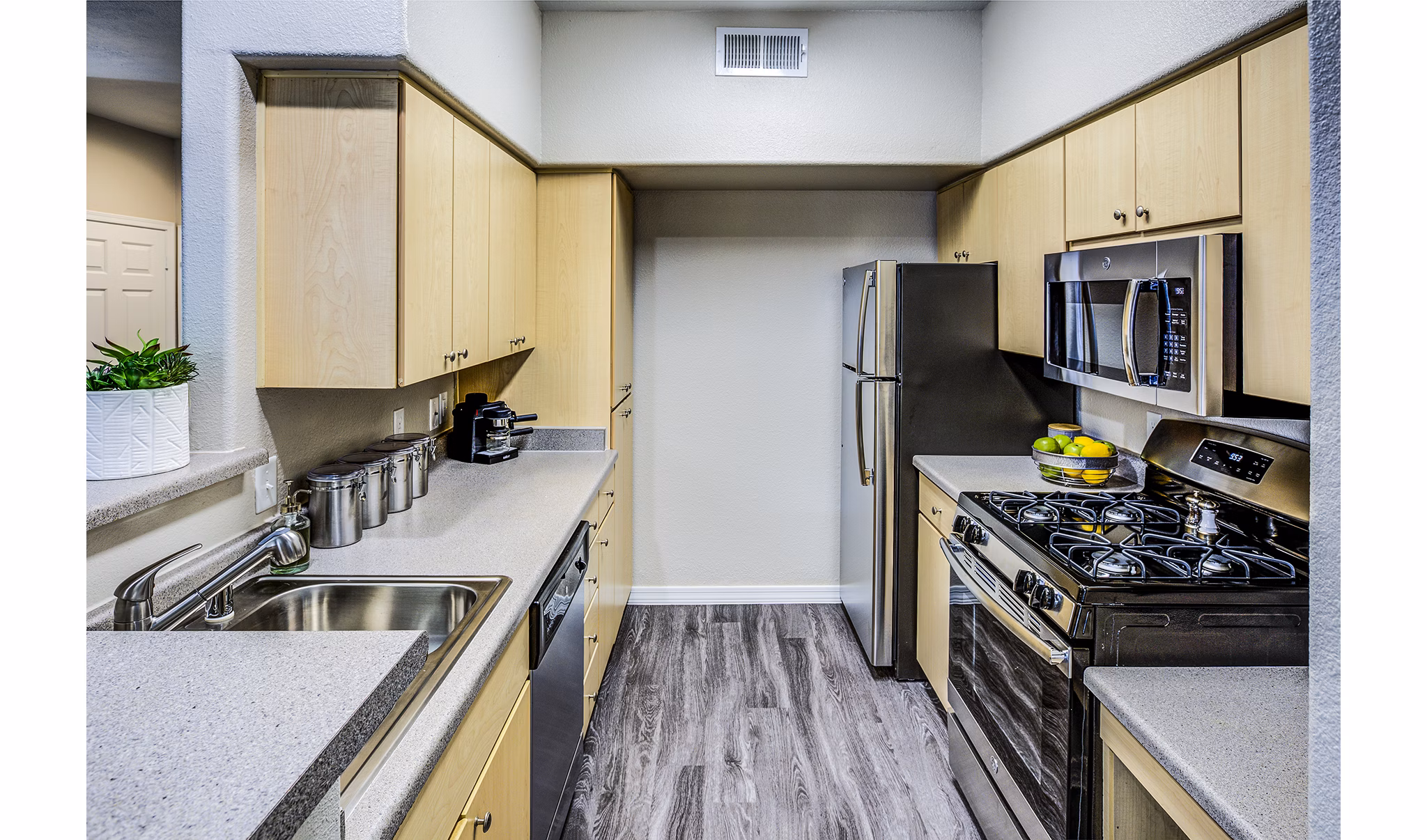 Modern kitchen with stainless steel appliances at Laguna at Arrowhead Ranch Apartments