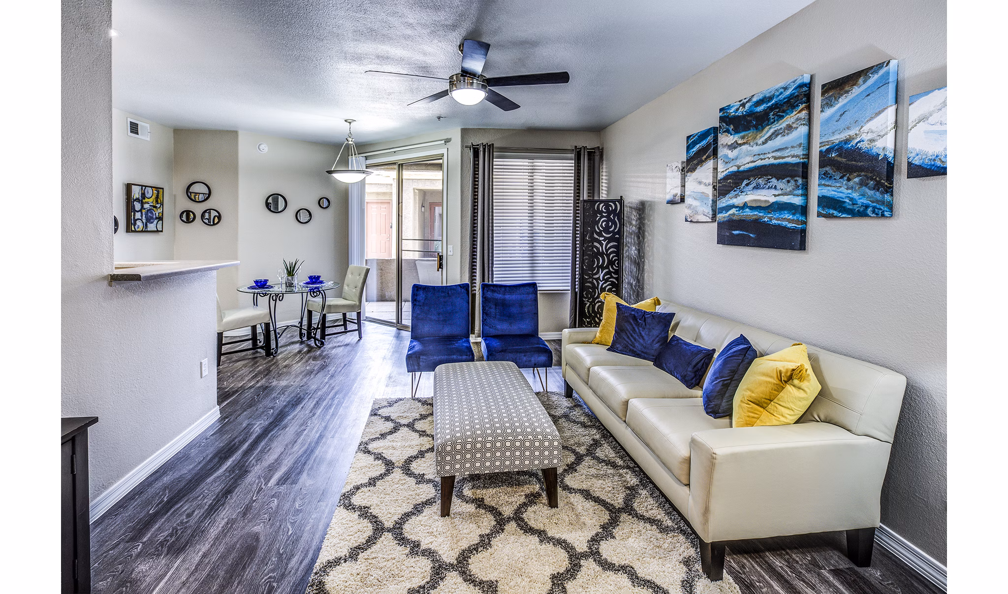 Modern living room with stylish decor and large windows at Laguna at Arrowhead Ranch Apartments
