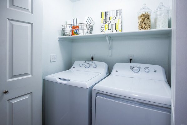 Laundry room with modern washers and dryers at Laguna at Arrowhead Ranch Apartments Ideal for convenient living in luxury apartments