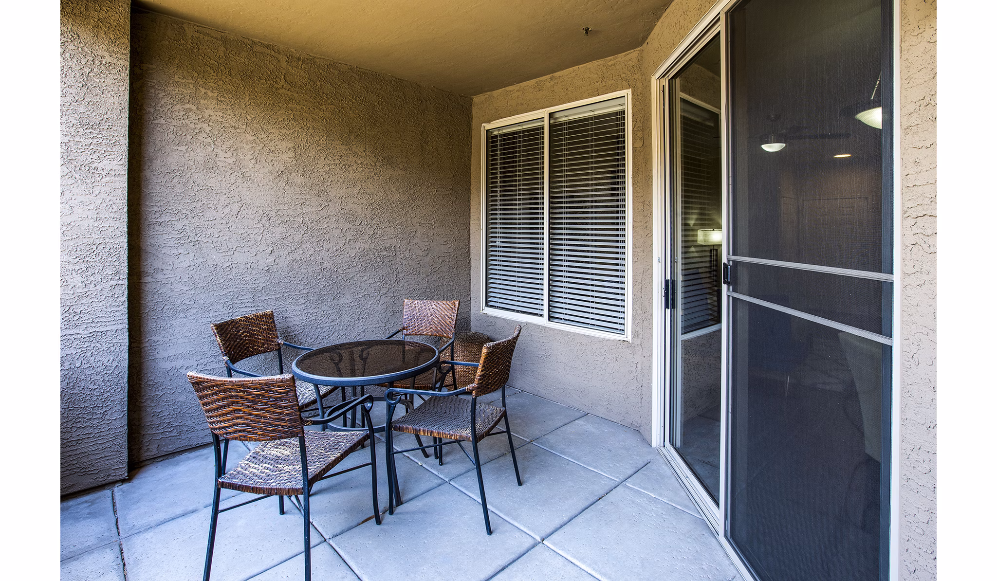 Charming balcony with seating at Laguna at Arrowhead Ranch apartments, overlooking scenic views in a luxury Greystar community