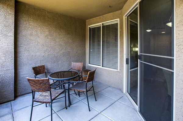 Charming balcony with seating at Laguna at Arrowhead Ranch apartments, overlooking scenic views in a luxury Greystar community