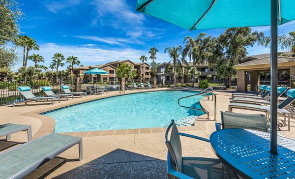 Outdoor pool with palm trees at Laguna at Arrowhead Ranch Apartments, offering a luxurious relaxation spot in Glendale