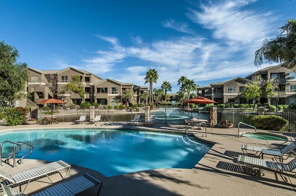 Resort-style pool with palm trees at Laguna at Arrowhead Ranch Apartments, offering luxury leisure spaces in Glendale