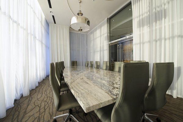 Meeting room with modern furnishings and large conference table at 2929 Weslayan Apartments