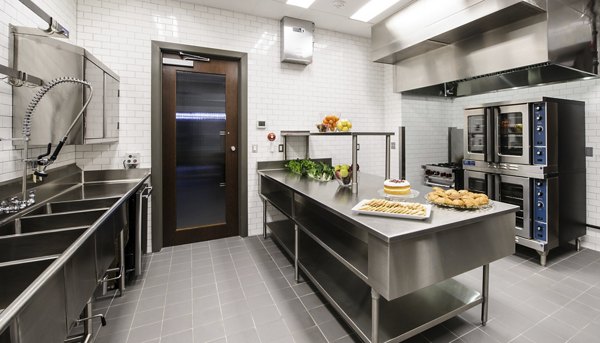 Modern clubhouse kitchen with marble countertops and bar seating at 2929 Weslayan Apartments