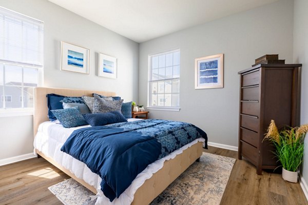 Cozy bedroom featuring modern decor and a large window at HeatherGate at Oxford Valley Apartments