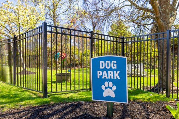 Spacious dog park at HeatherGate at Oxford Valley Apartments with lush greenery and shaded seating areas for residents and their pets