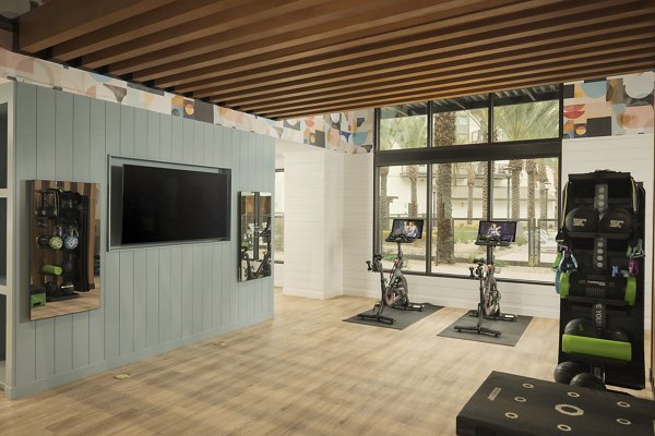 Yoga/spin studio with modern equipment at The Tyler Apartments, offering fitness options for residents in a luxury setting
