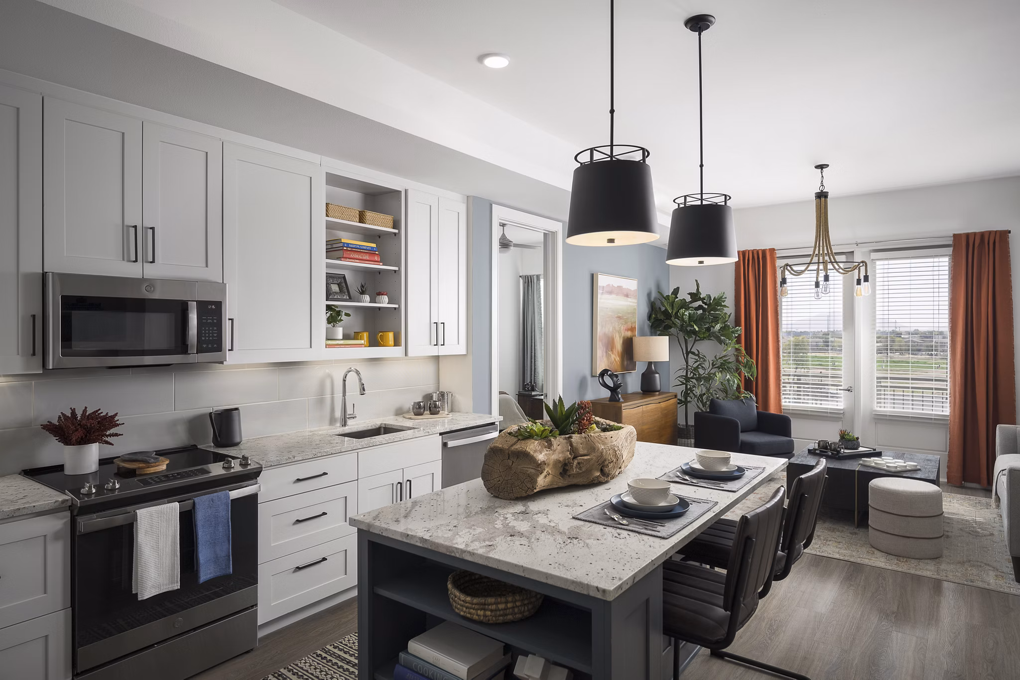 Modern kitchen with stainless steel appliances and granite countertops in The Tyler Apartments, luxury living by Greystar