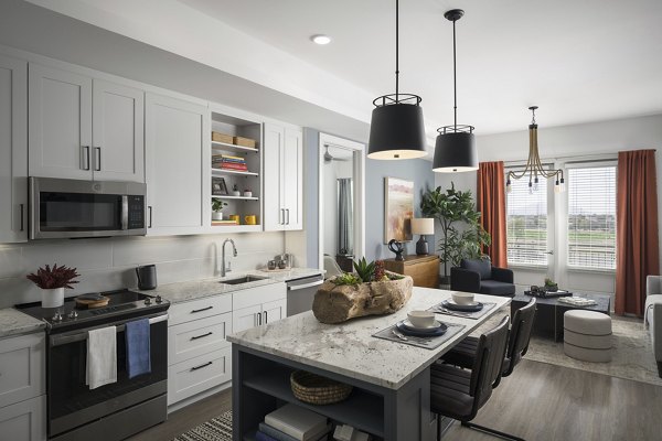 Modern kitchen with stainless steel appliances and granite countertops in The Tyler Apartments, luxury living by Greystar