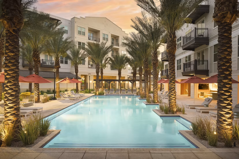 Modern pool surrounded by loungers at The Tyler Apartments, offering a luxurious retreat for residents