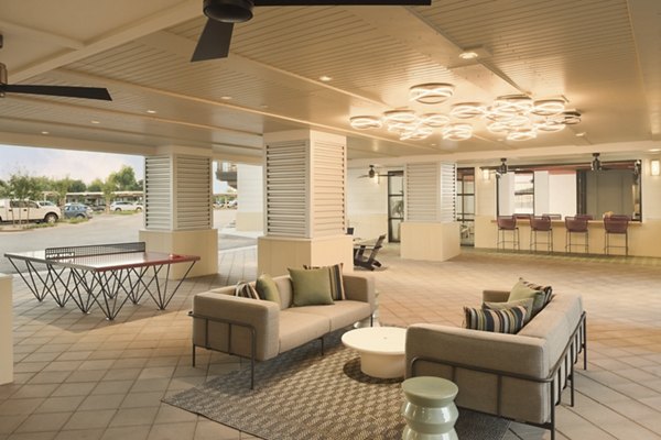 Patio with modern furniture and lush greenery at The Tyler Apartments