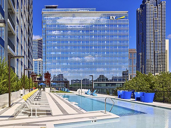Resort-style pool at Generation Atlanta Apartments with modern lounge chairs and skyline views