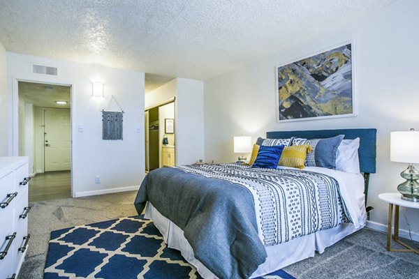 Cozy bedroom with modern design at Stride West Apartments, featuring plush bedding and ample natural light for a relaxing retreat