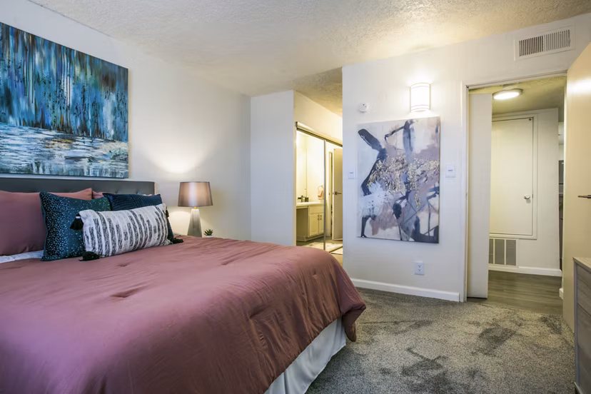 Cozy bedroom with modern furnishings at Stride West Apartment, luxury living by Greystar