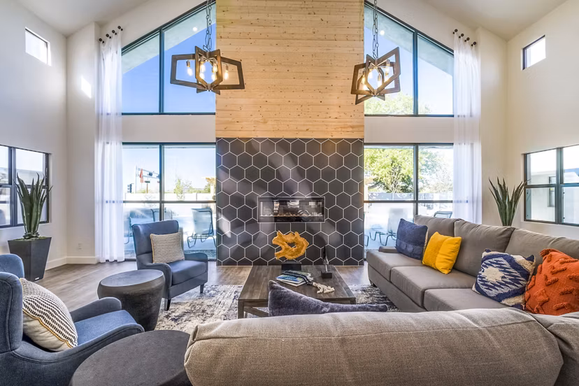 Modern living room with large windows and stylish furniture featuring a fireplace