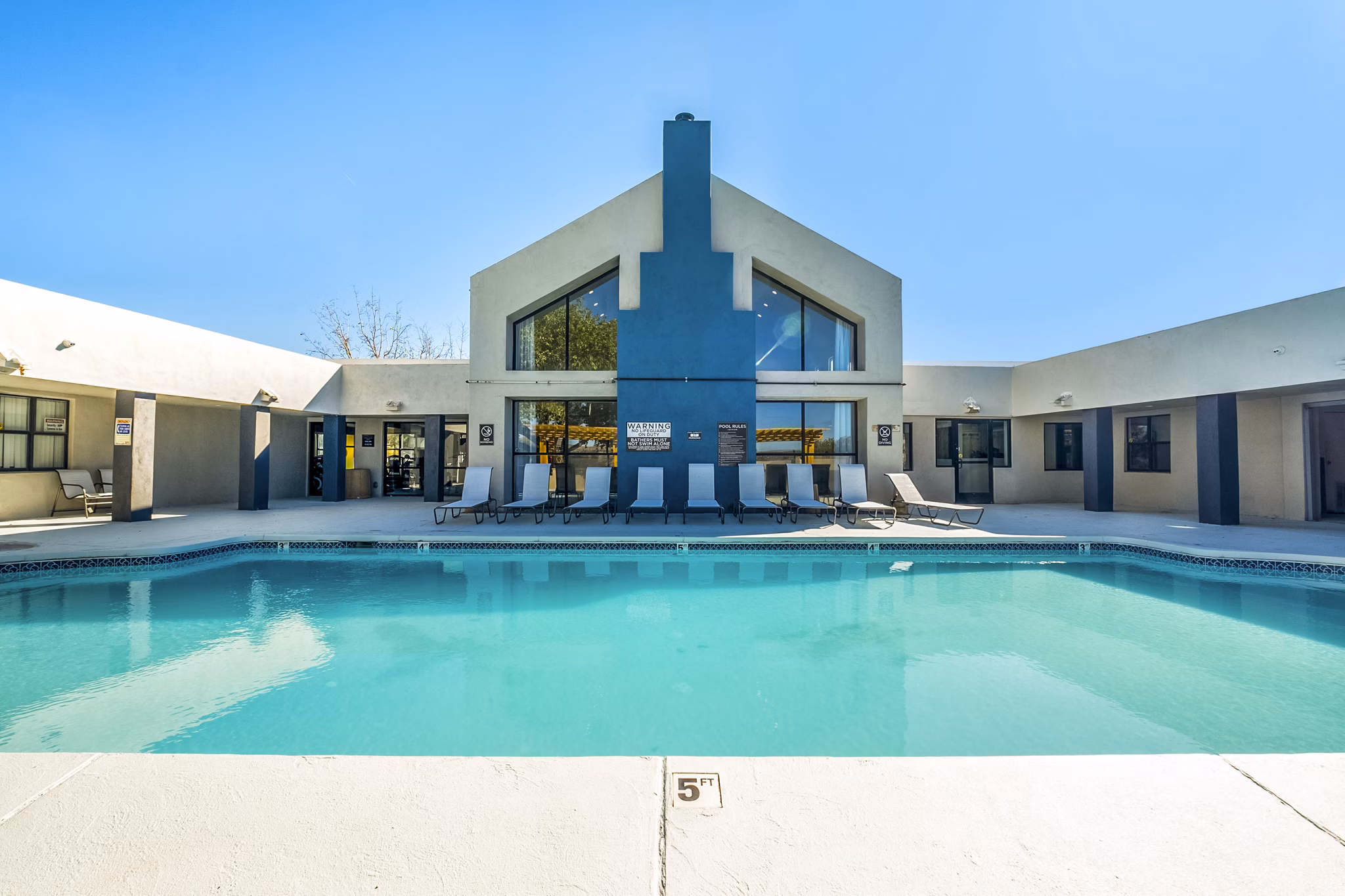 Outdoor pool surrounded by lush greenery at Stride West Apartments