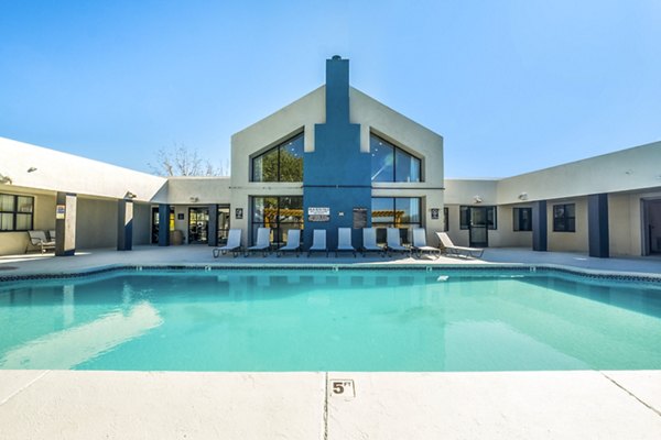 Outdoor pool surrounded by lush greenery at Stride West Apartments