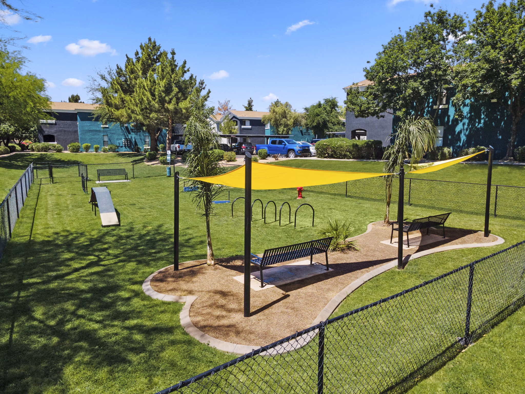 Spacious dog park featuring agility equipment at Morada Grande Apartments, perfect for residents and their pets to enjoy the outdoors