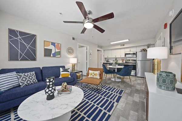 Modern living room with large windows and sleek furniture at Morada Sky Apartments