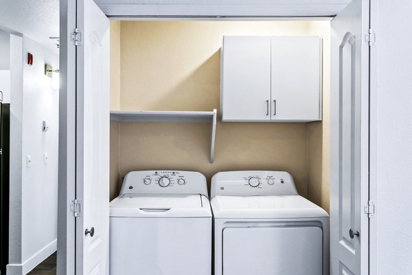 Laundry room with modern washers and dryers at The Urban Apartments, a Greystar luxury community