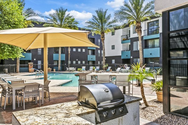 Outdoor grill area with modern patio seating at The Urban Apartments, perfect for summer cookouts and relaxation