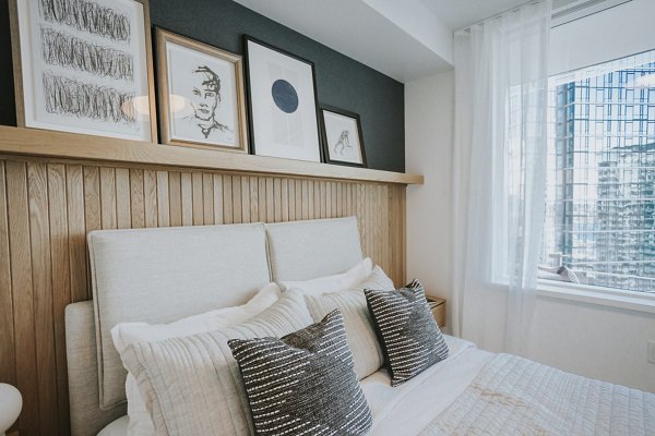 Bedroom with modern decor and large windows at REN Apartments