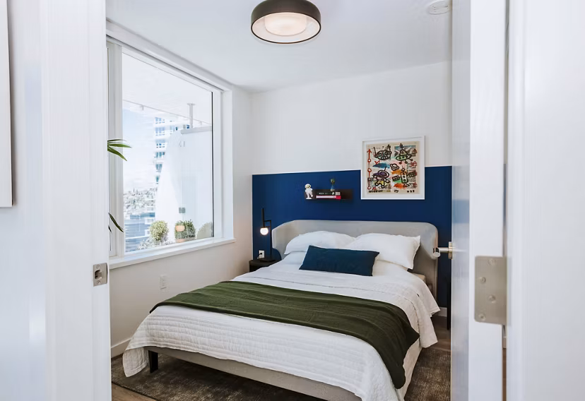 Cozy bedroom with modern furnishings at REN Apartments, showcasing luxury and comfort in an upscale city living environment