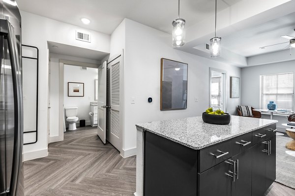 Spacious kitchen with granite countertops and modern appliances in Nexus at Goodnight Ranch Apartments
