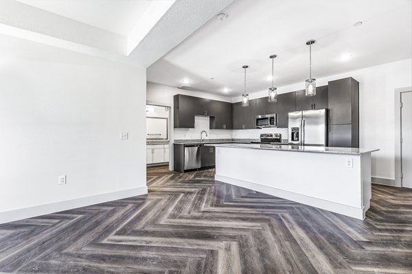 Open-concept kitchen and dining area with modern finishes in Nexus at Goodnight Ranch Apartments