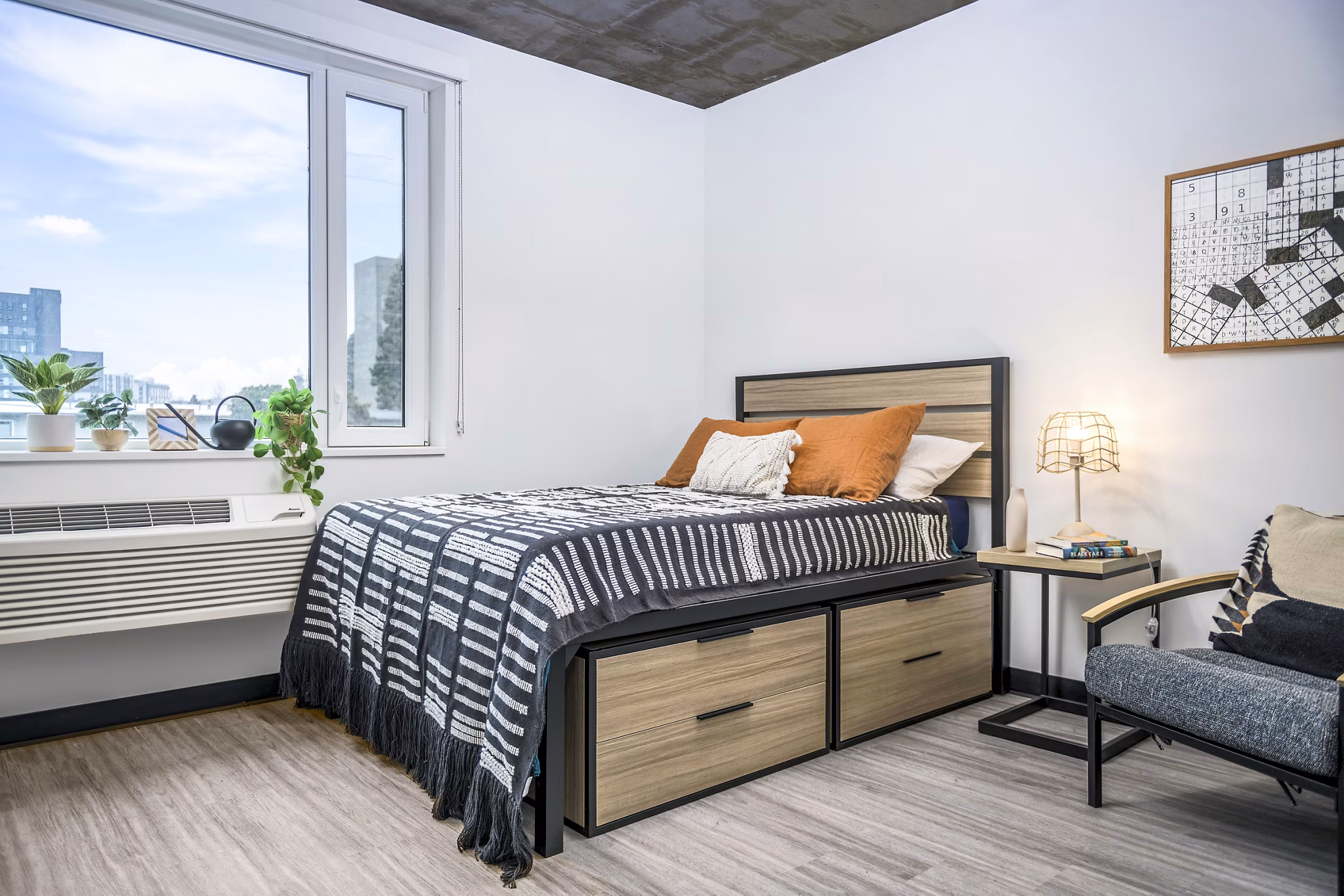 Bedroom with modern furnishings and city views at Union on Broadway Apartments