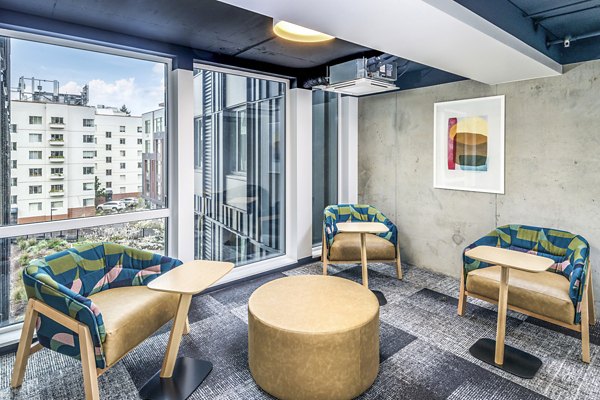 Clubhouse study area featuring modern furniture and ample lighting at Union on Broadway Apartments