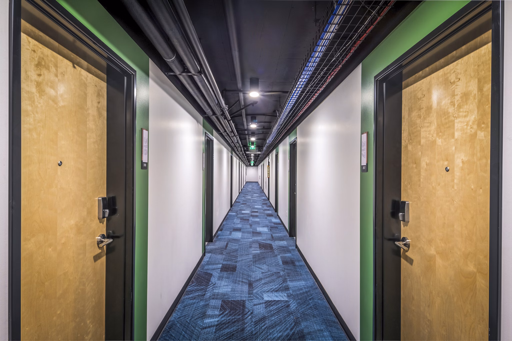 Hallway leading to residences at Union on Broadway Apartments, featuring modern lighting and contemporary design elements