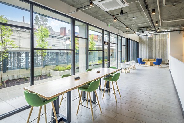 Clubhouse study area with modern seating and large windows at Union on Broadway Apartments