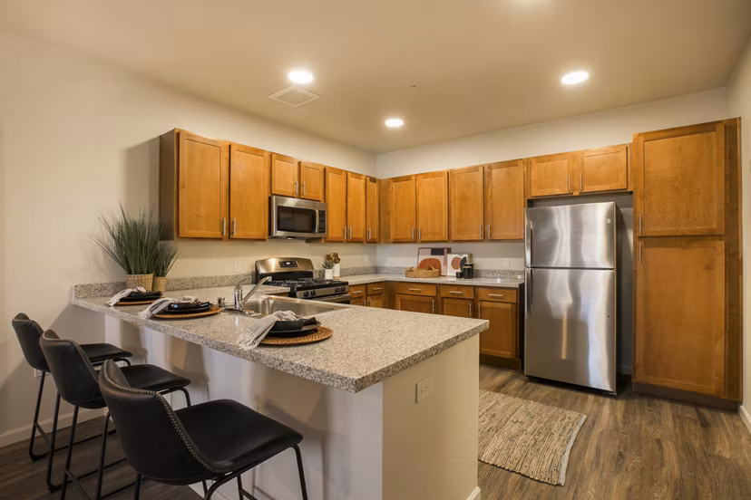 Modern kitchen with stainless steel appliances and granite countertops in South Meadows Apartments