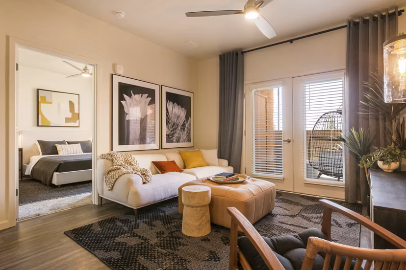 Spacious living room with modern decor and large windows in South Meadows Apartments