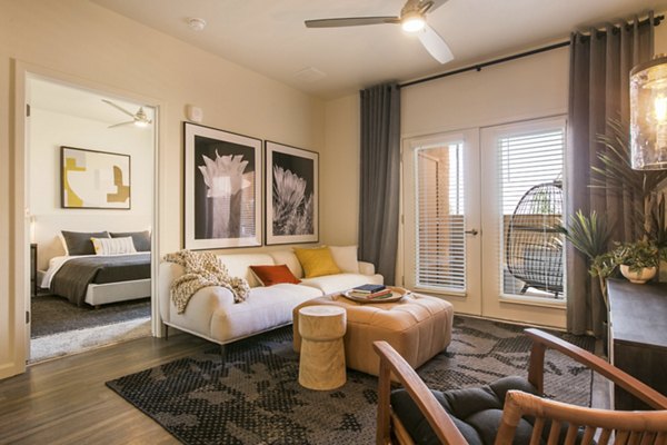 Spacious living room with modern decor and large windows in South Meadows Apartments