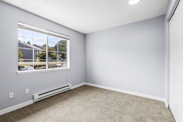 Luxurious bedroom featuring modern decor and ample natural light at Avana West Hill Apartments