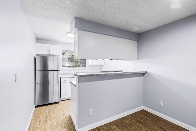 Dining room with elegant lighting and hardwood floors in Avana West Hill Apartments