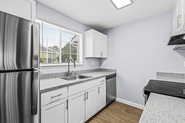 Modern kitchen featuring granite countertops and stainless steel appliances at Avana West Hill Apartments